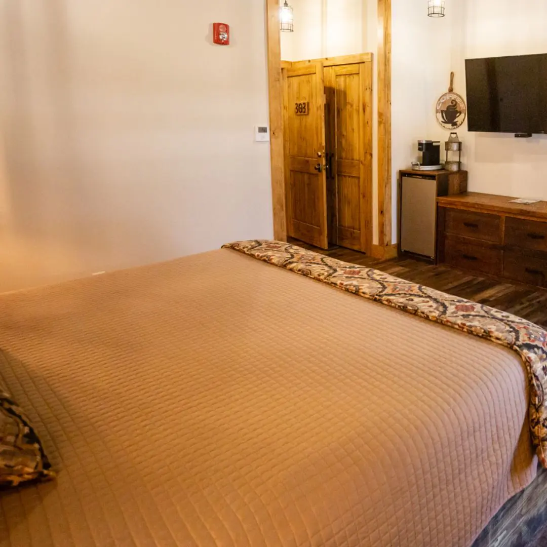 Hotel room with bed and wooden decor.