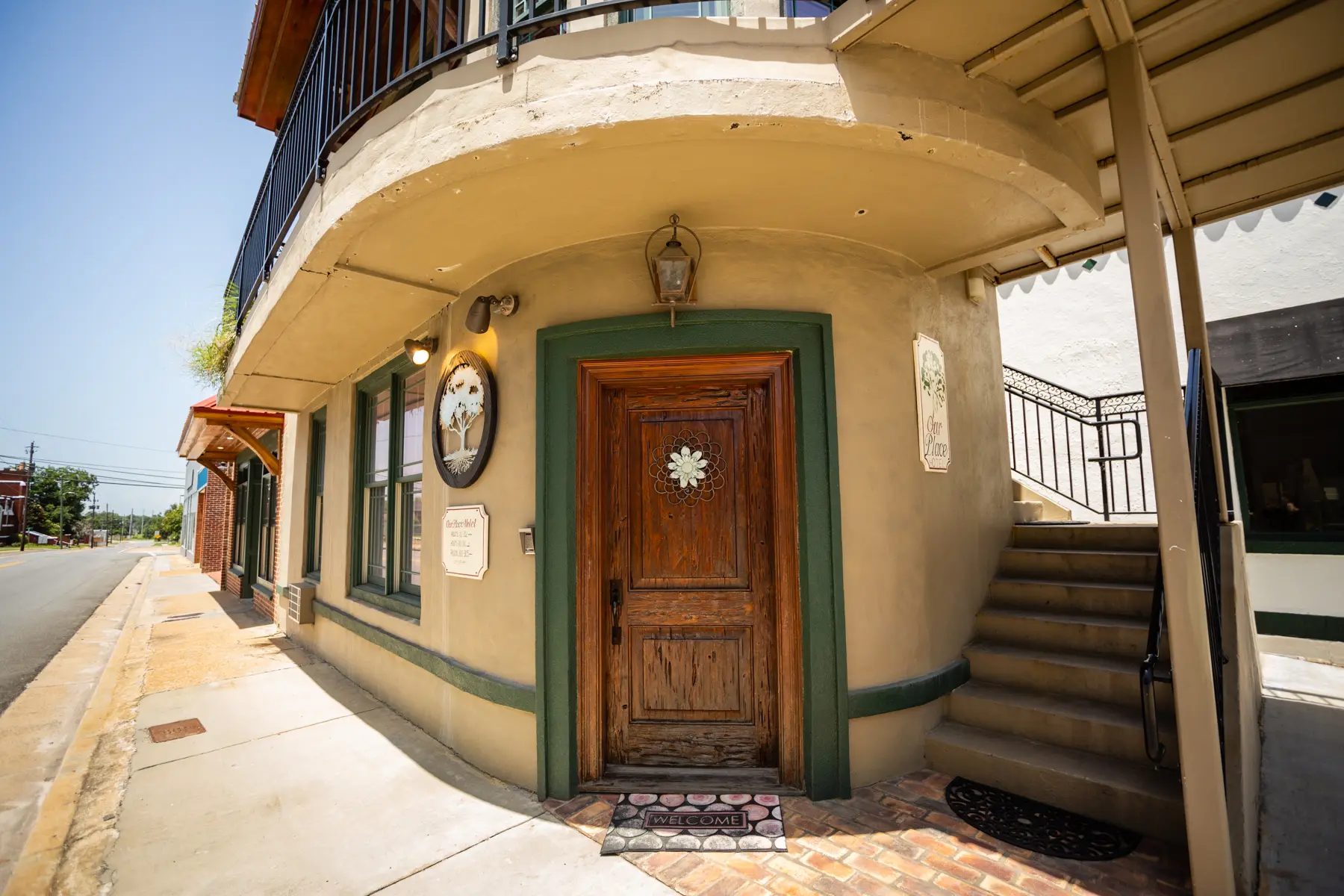 Cozy corner doorway with wooden door and vintage clock outside.