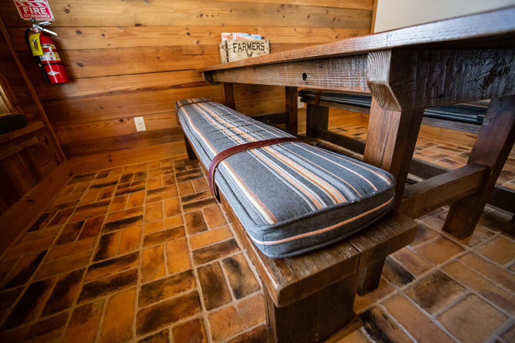 Wooden bench with striped cushions in a cozy indoor space.
