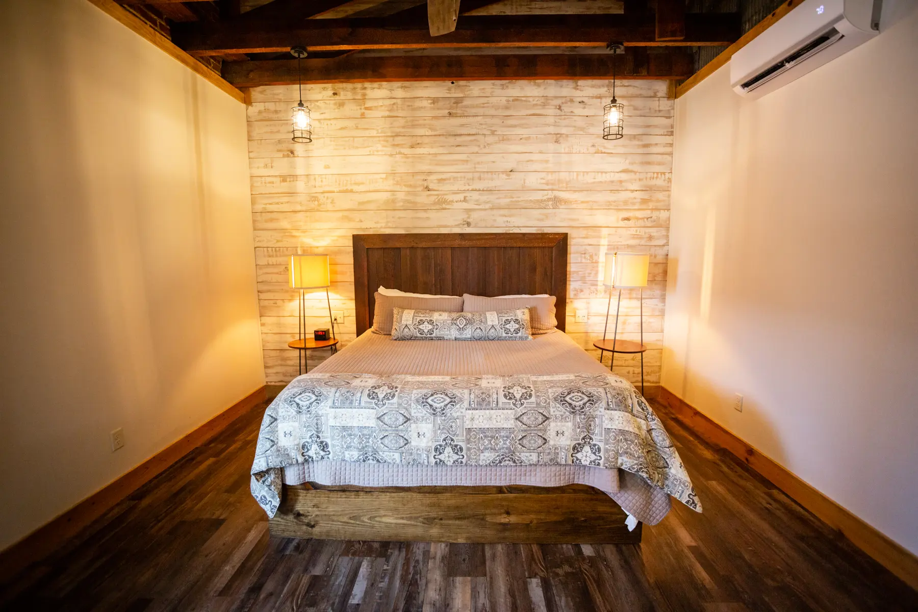 Cozy bedroom with exposed brick and warm lighting.