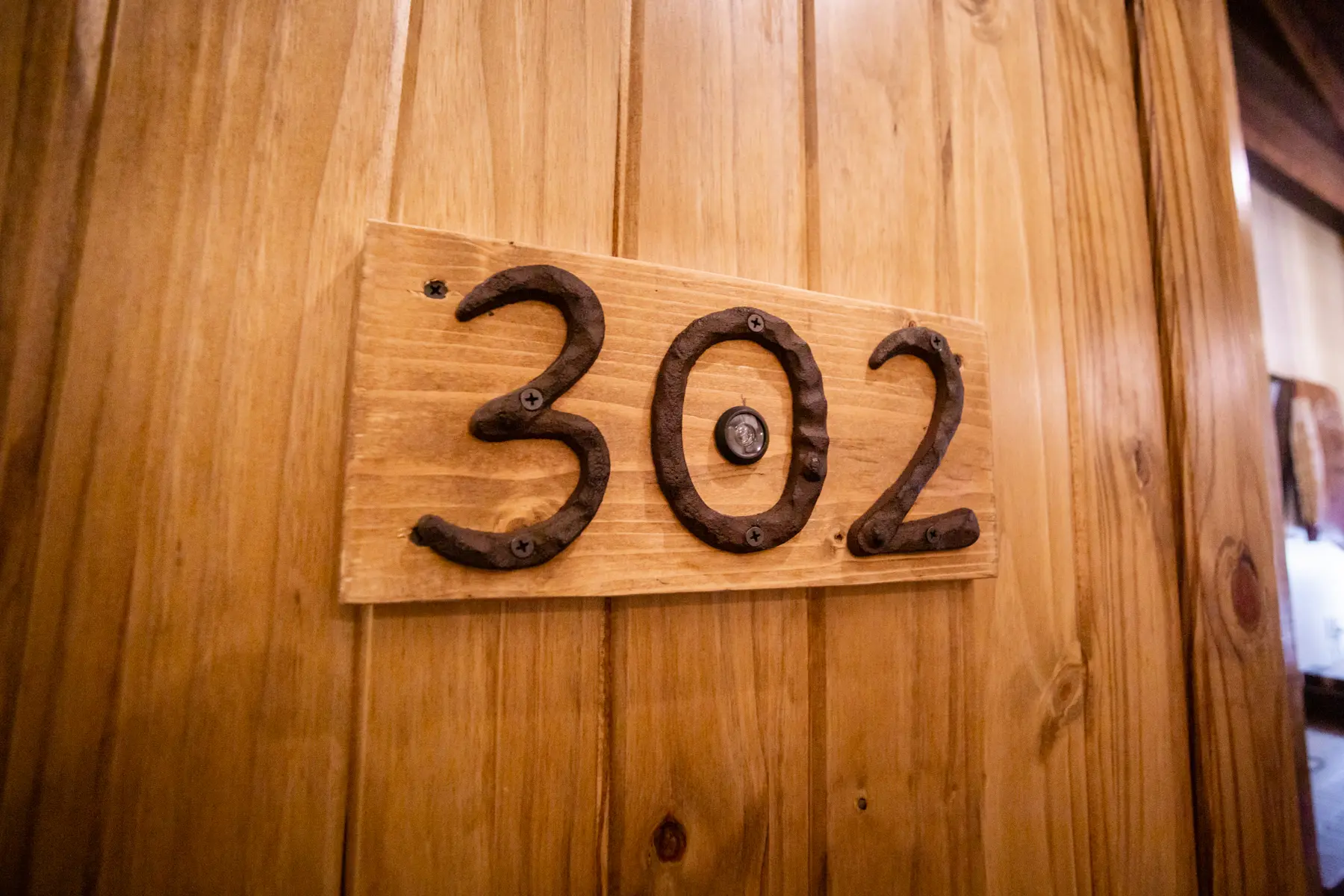 Room number 302 displayed with horseshoes on a wooden plaque.