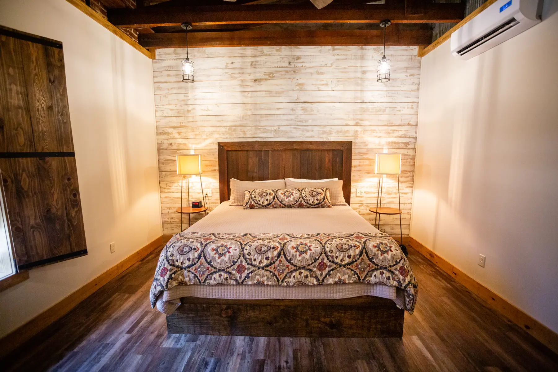 Cozy rustic bedroom with wooden beams and warm lighting.